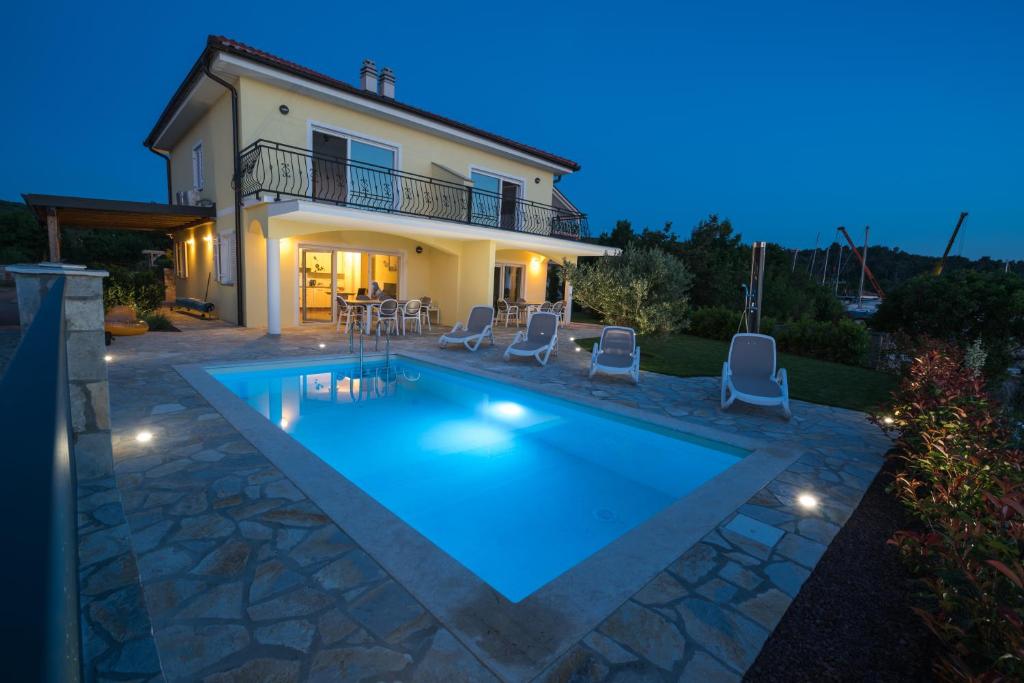 una villa con piscina di fronte a una casa di Villa Claudia a Klimno