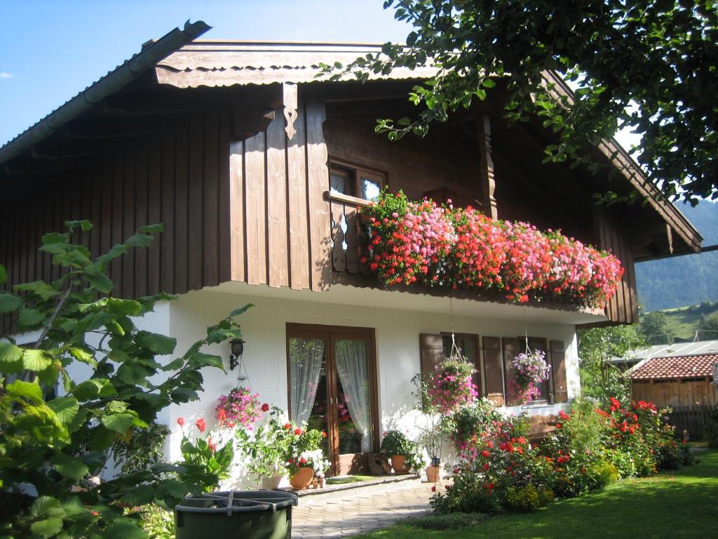 une maison avec des fleurs sur son côté dans l'établissement Gästehaus Proisl, à Lenggries