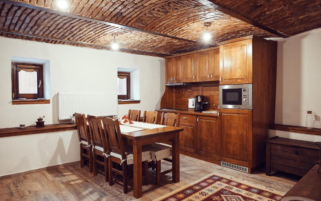 a kitchen with wooden cabinets and a table with chairs at Cozy Apartment in Braşov