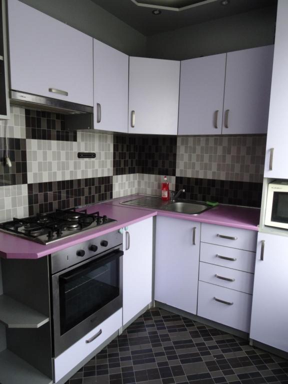 a kitchen with white cabinets and a stove top oven at Apart Gagarina in Kropyvnytskyi