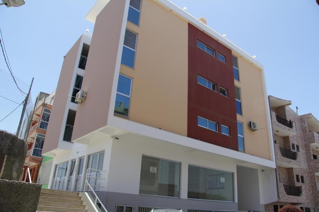 an apartment building with red doors and stairs at Dream Apartment in Praia