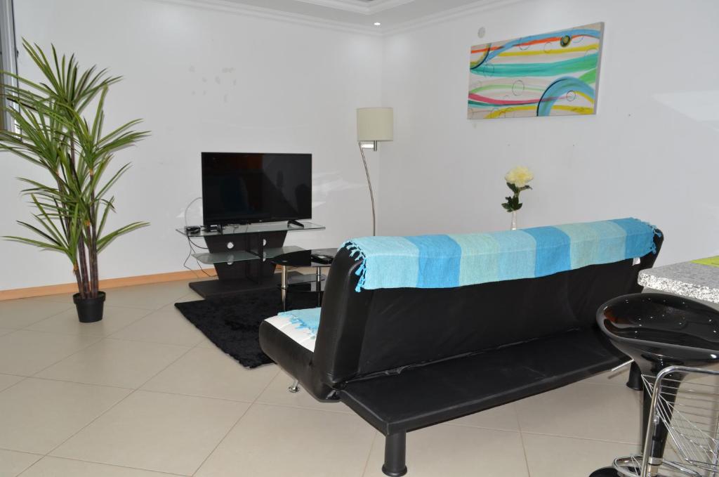ein Wohnzimmer mit Couch und Flachbildfernseher in der Unterkunft Apartamento Augusto in Praia