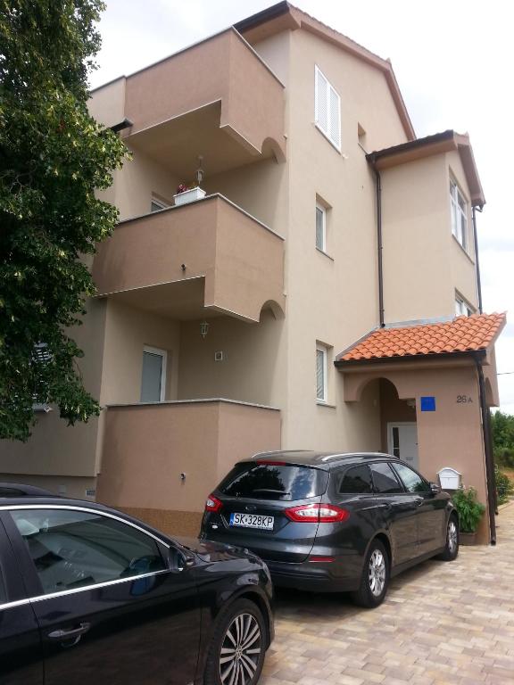 two cars parked in front of a building at Apartments Roncevic in Zadar