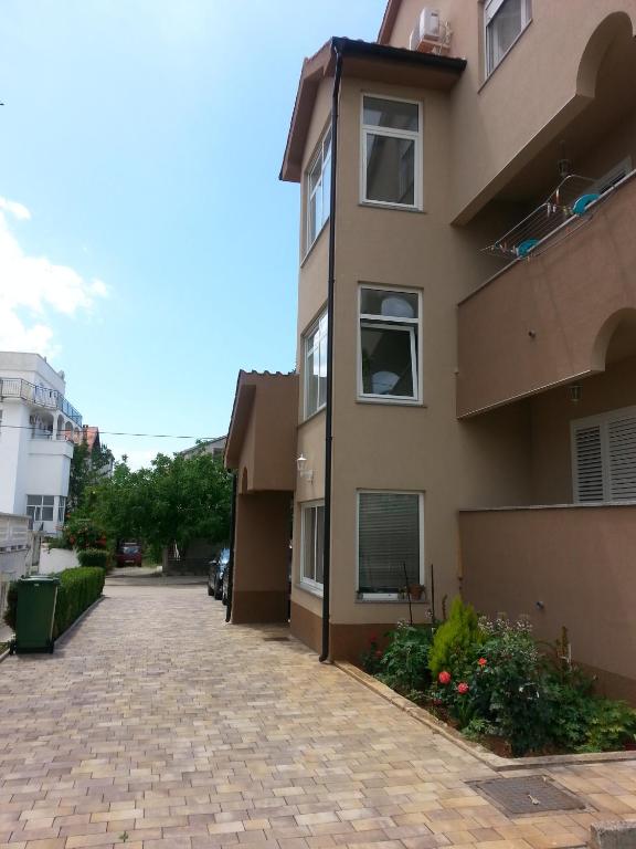 an apartment building with a brick driveway at Apartments Roncevic in Zadar