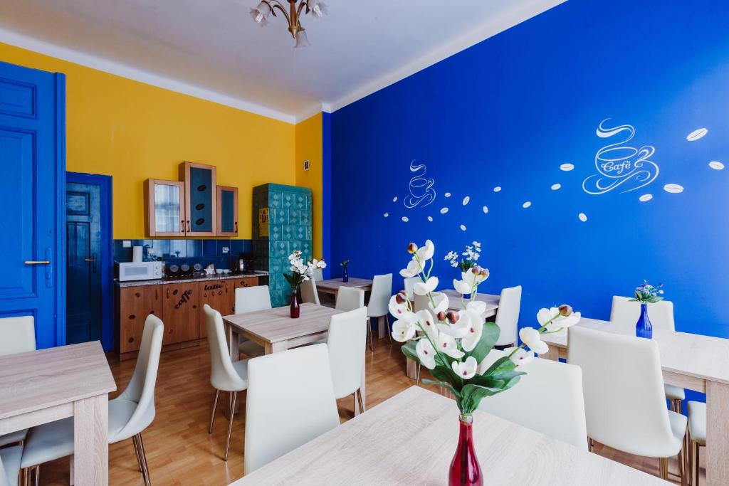 een eetkamer met blauwe en gele muren en tafels en stoelen bij Hostel Tara in Krakau