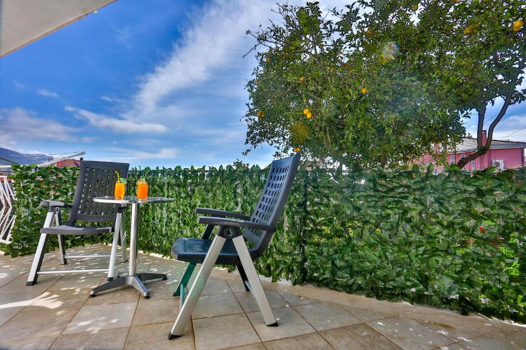 two chairs and a table in front of a hedge at Luxury apartment M&N in Split in Split