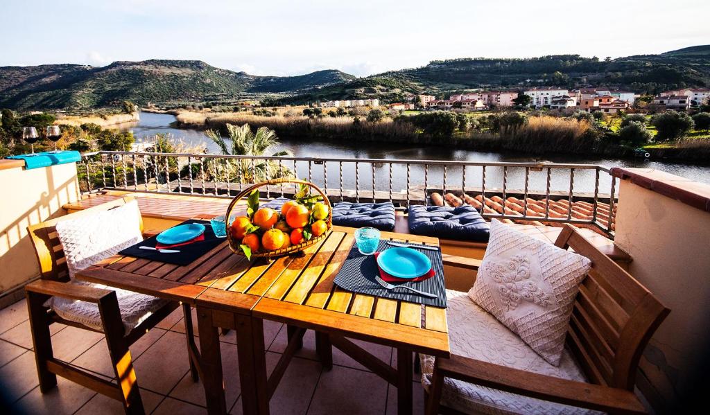 un tavolo con un cesto di frutta sul balcone di Bosa Apartments "Attic On The River" a Bosa