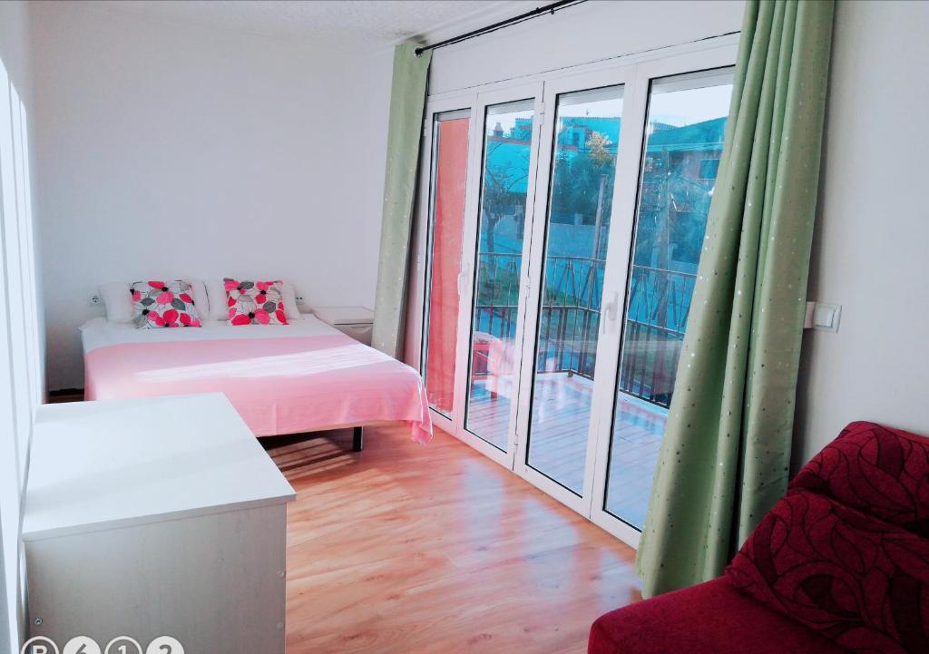 テラサにあるLa Casa de Vacacionesのベッド1台、窓、バルコニーが備わる客室です。