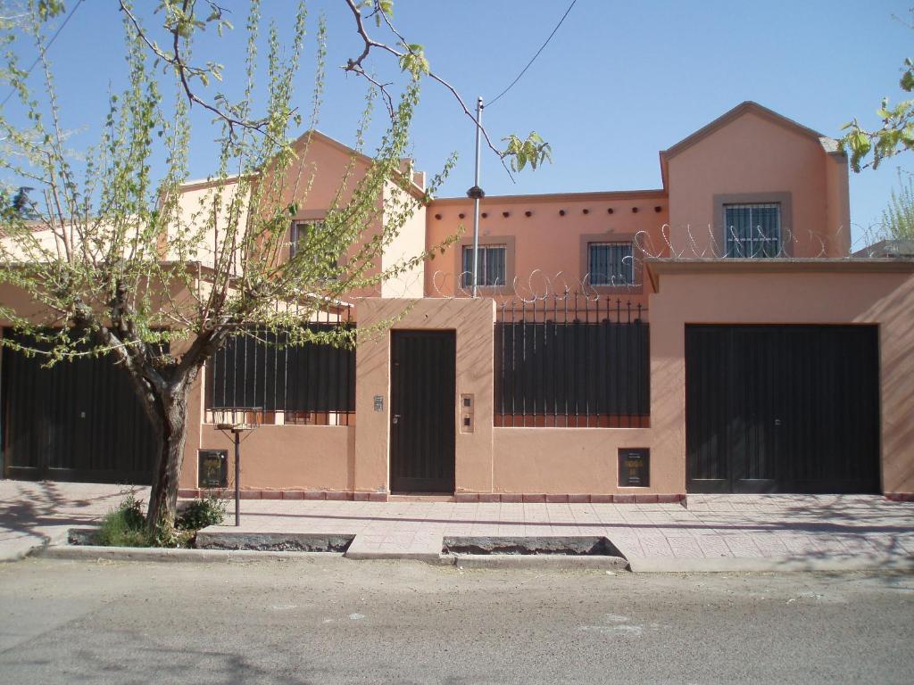 um edifício rosa com uma árvore em frente em Duplex Paraíso em Villa Nueva