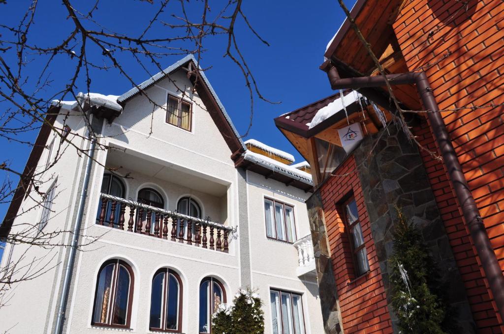 a white building with a balcony on top of it at Sadyba Girske Povitria in Yaremche