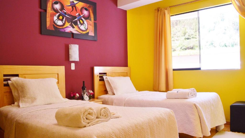 2 camas en una habitación con paredes amarillas y rojas en Samay Wasi Hotel Chalhuanca, en Chalhuanca
