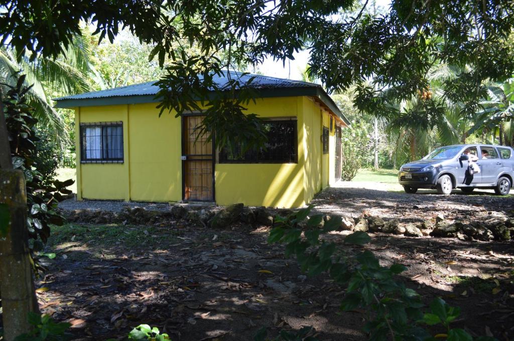 a yellow house with a car parked in front of it at Casita Amarilla in Cahuita