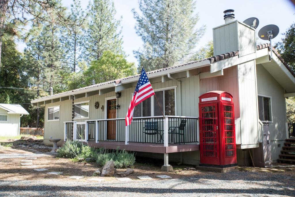 a house with a red phone booth and an american flag at Lovely Mountain Lake Chalet by Yosemite: Equipped! in Groveland