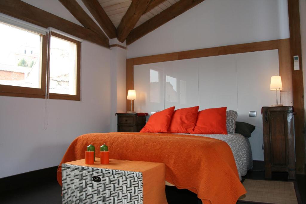 1 dormitorio con cama con sábanas de color naranja y ventana en Casa Rural Velliza, en Velliza