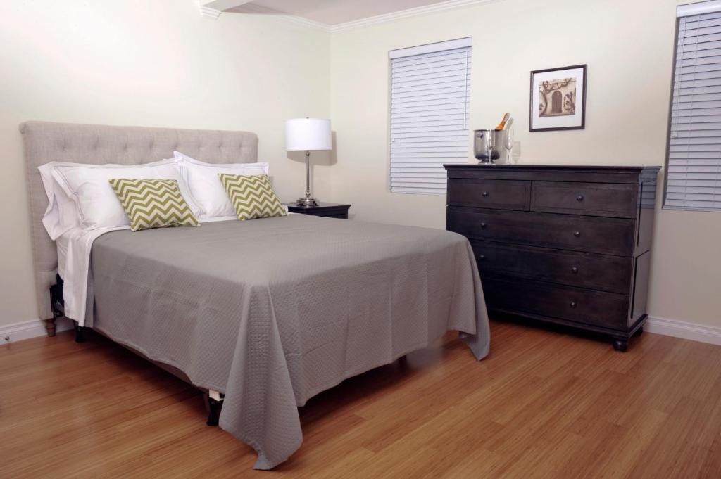 a bedroom with a bed and a dresser at Bricco Suites in Boston