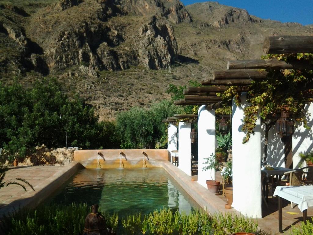un charco de agua con una montaña en el fondo en Hotel Rural Cortijo La Alberca en Níjar