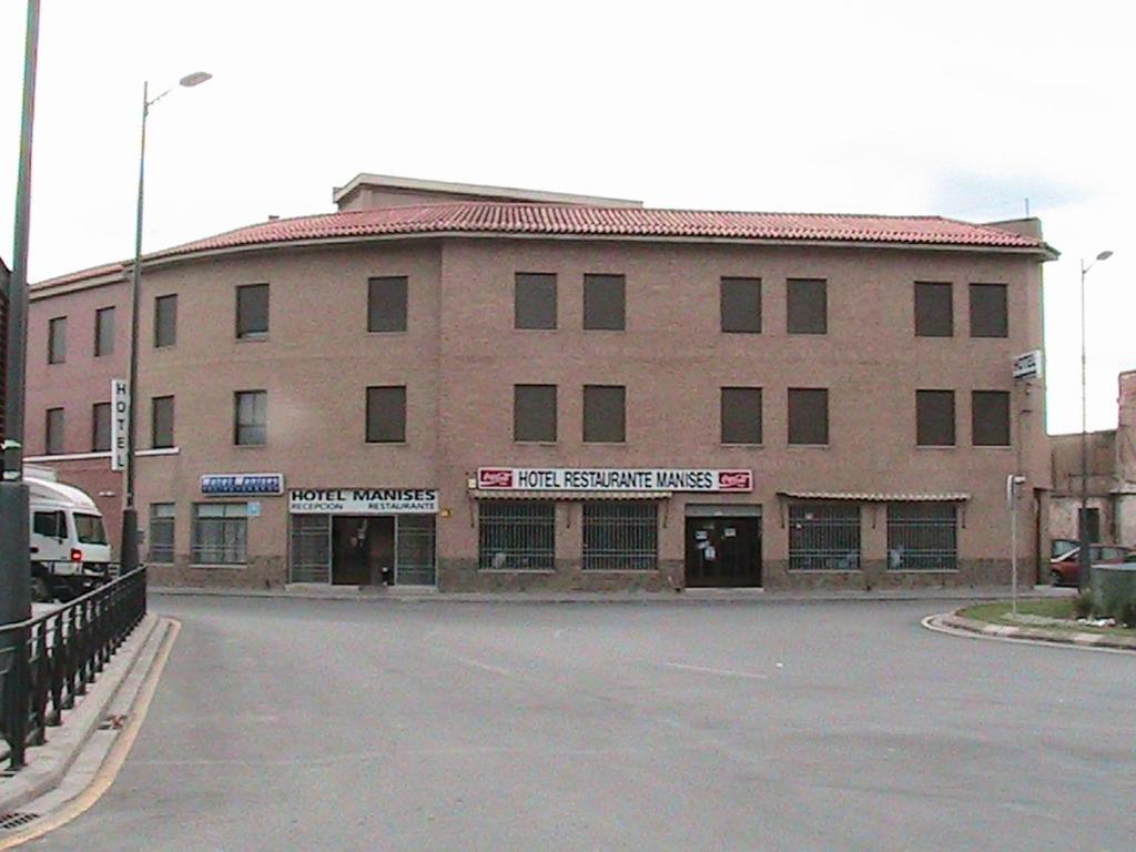 un grande edificio in mattoni con un parcheggio di fronte di Hotel Manises a Manises