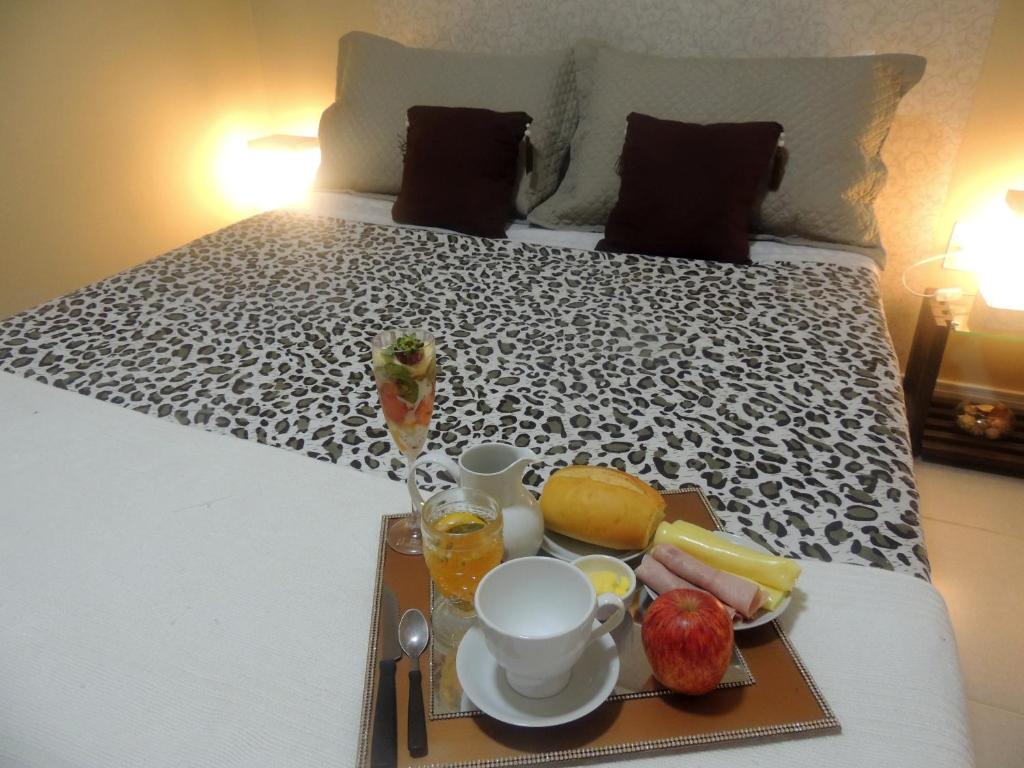 a tray of breakfast food on a bed at Casa 1 dormitório prox da praia in Itapema