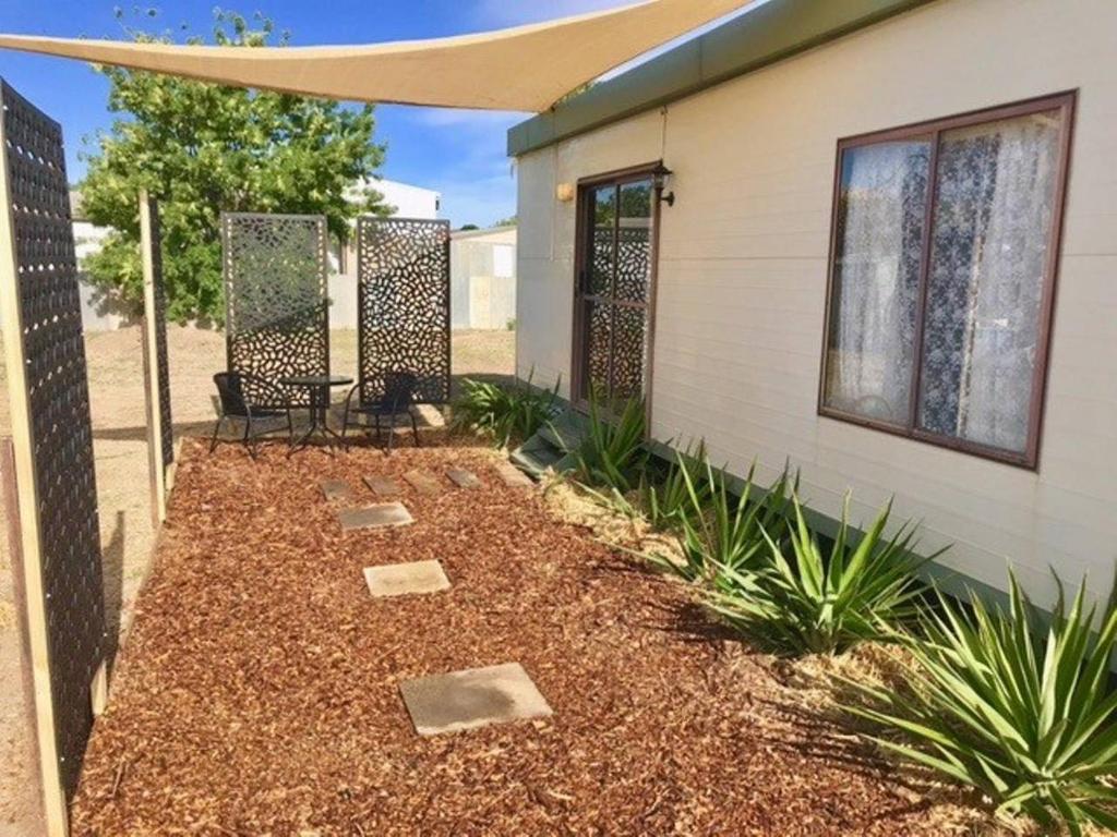 a patio with a table and chairs in front of a house at Cute Private Studio Flat with AIRCON! in Hay