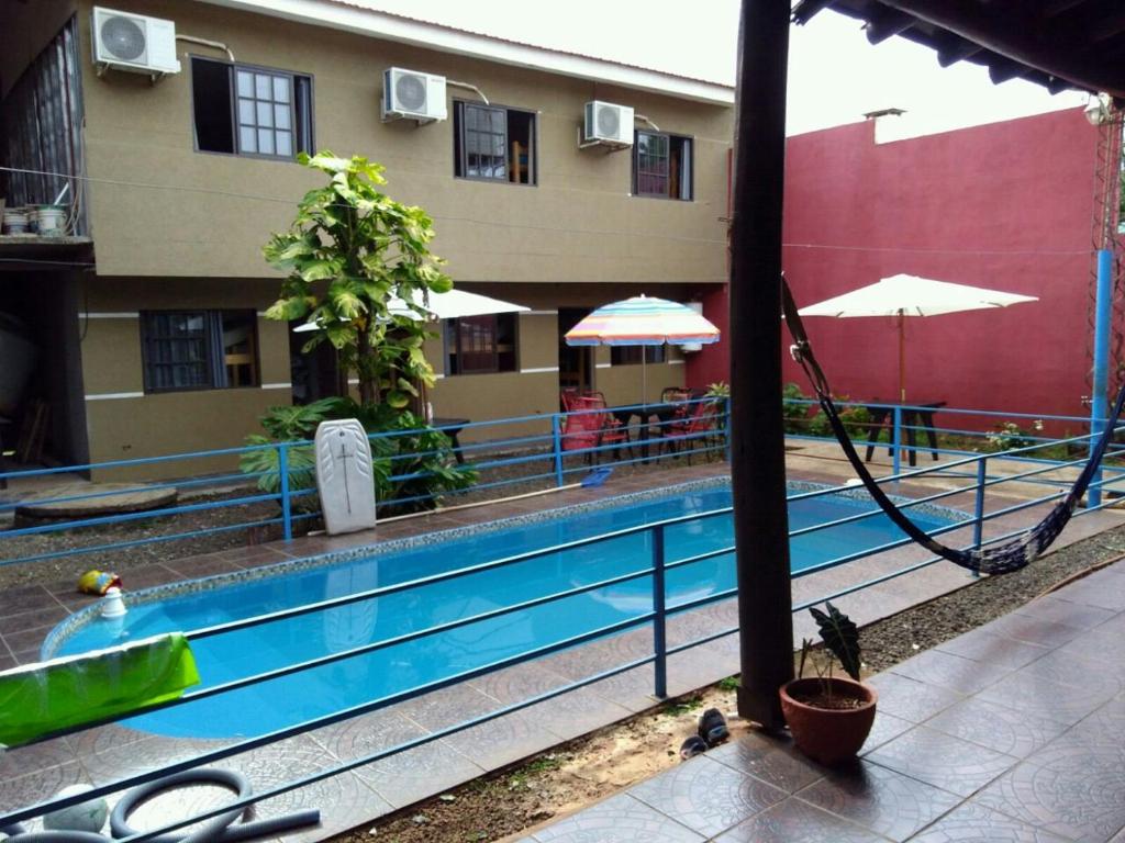 a swimming pool in front of a building at Fariña hospedajes in Puerto Iguazú