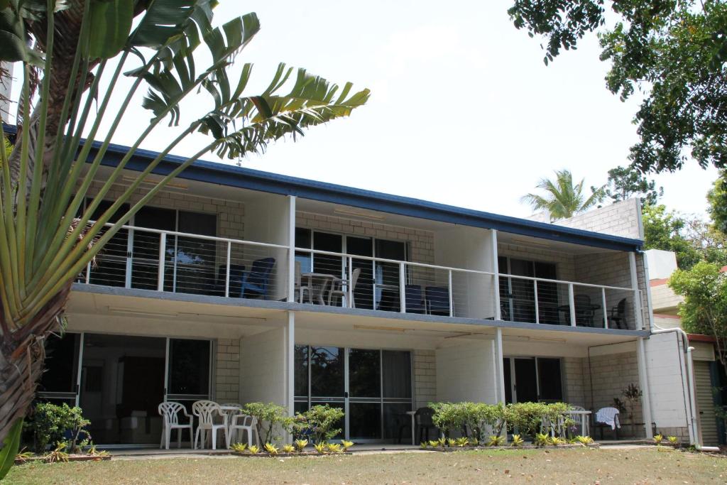 a large white building with tables and chairs at Whitehaven Beachfront Holiday Units in Airlie Beach