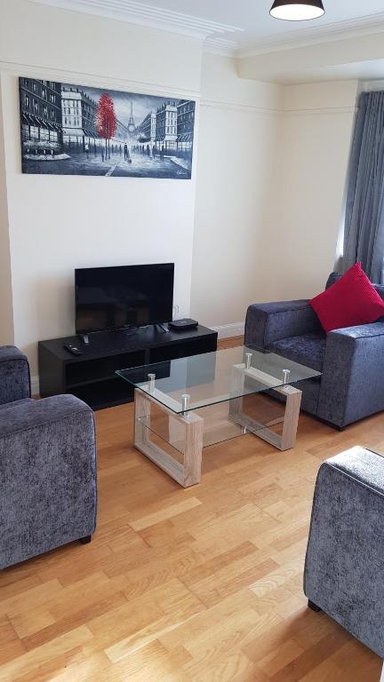 a living room with two couches and a glass coffee table at Elegant and spacious 2 bedroom in Barnet