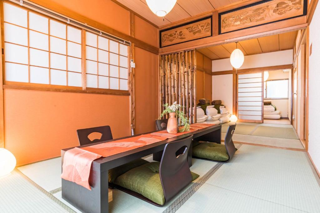 大阪市にあるKAON IKOI -Japanese style house-のオレンジ色の壁のダイニングルーム(テーブル、椅子付)