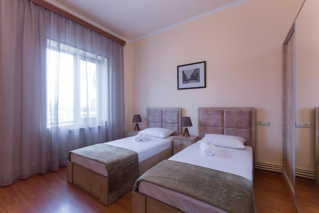 a bedroom with two beds and a window at Umba Apartment N1 - 2 bedrooms in Yerevan