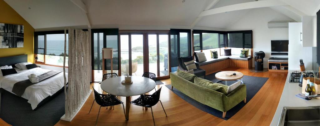 uma sala de estar com uma cama, um sofá e uma mesa em Points South By The Sea em Apollo Bay