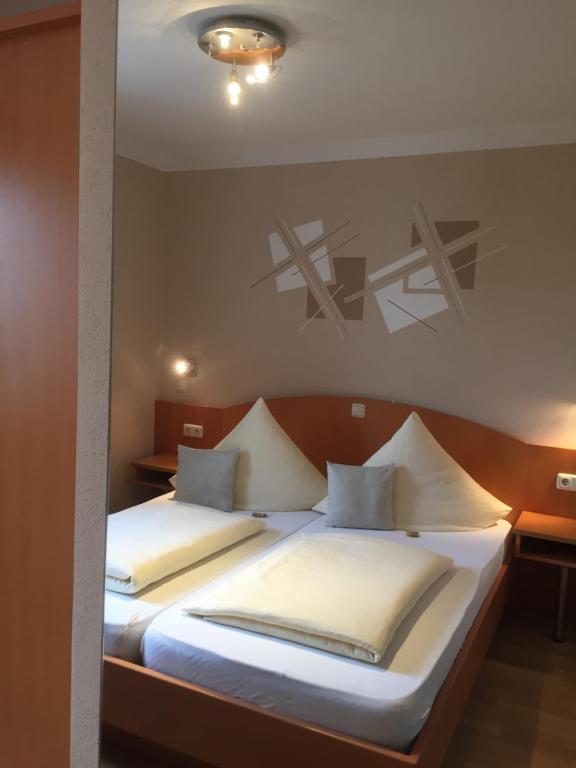 a bedroom with two beds with white pillows at Pension Wagner in Ingolstadt