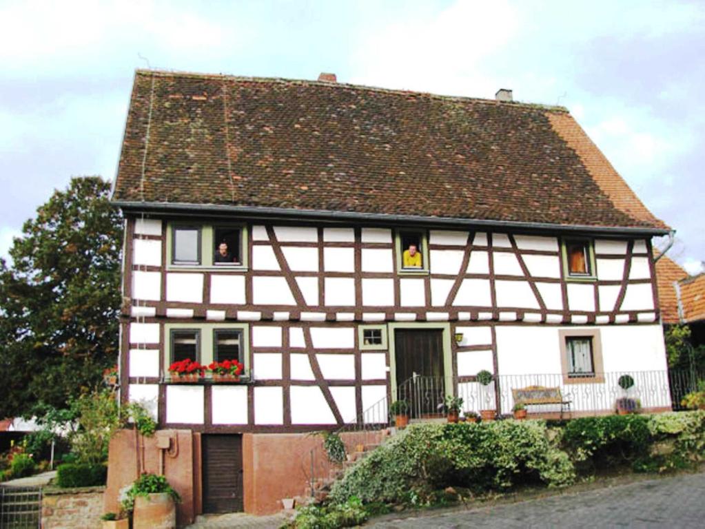 uma casa branca e preta com flores nas janelas em Bauernhof Heist em Langen-Brombach