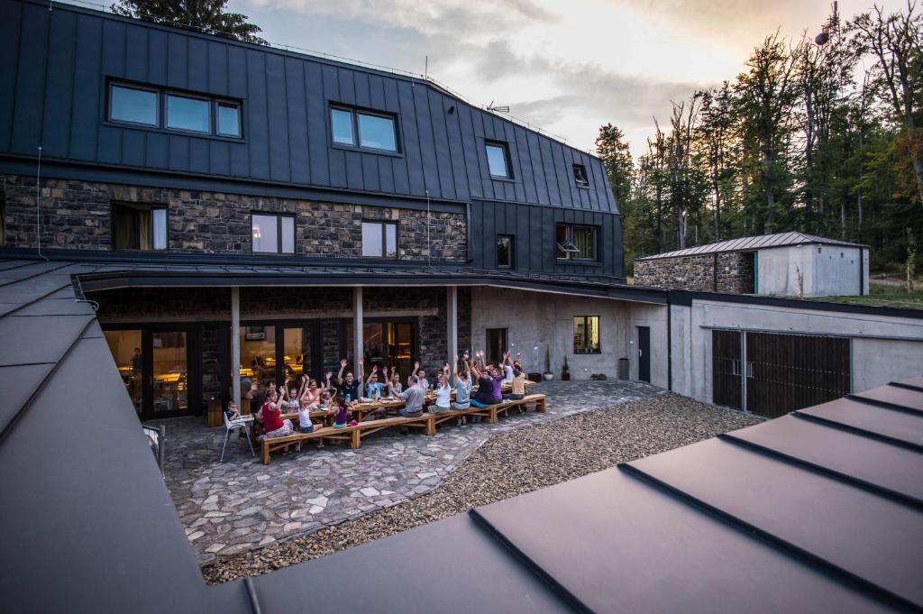 een groep mensen die buiten een gebouw op banken zitten bij Galyatető Turistacentrum in Galyatető