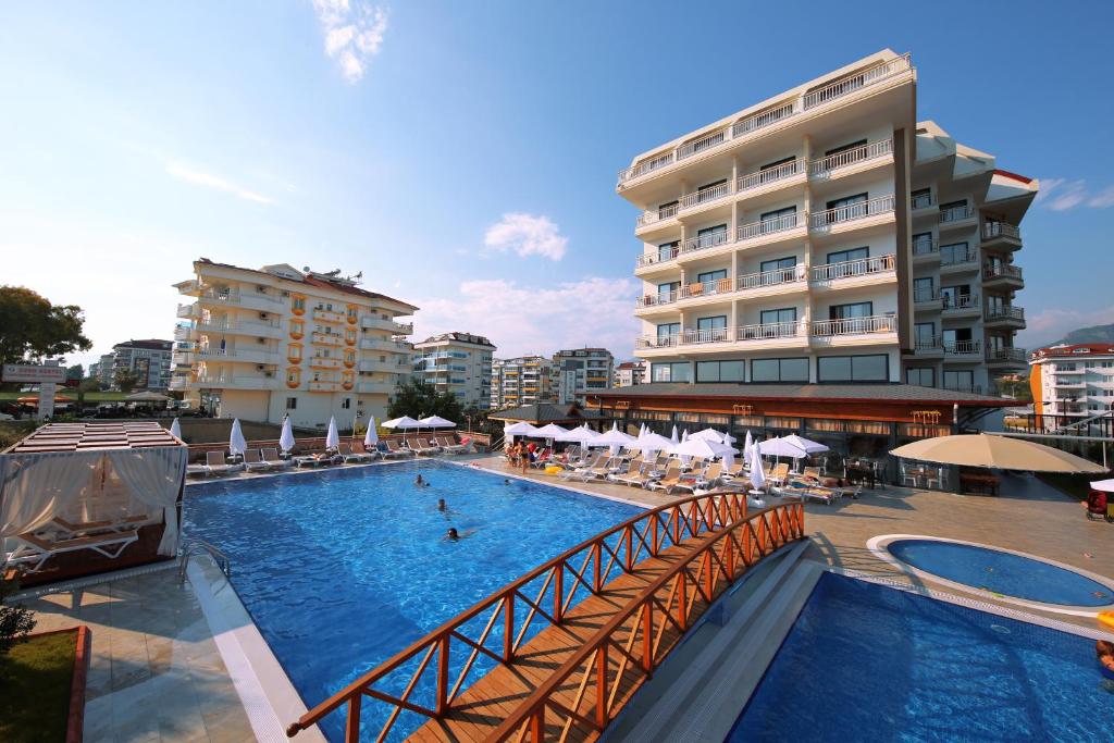 a large swimming pool with a bridge in front of a building at Sey Beach Hotel & Spa in Alanya