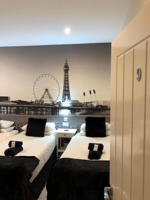 a room with three beds with a view of the eiffel tower at Happy Return Hotel in Blackpool