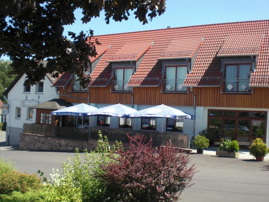 um edifício com guarda-chuvas à frente em Landgasthof Schubbkoarn's Ruh em Fulda