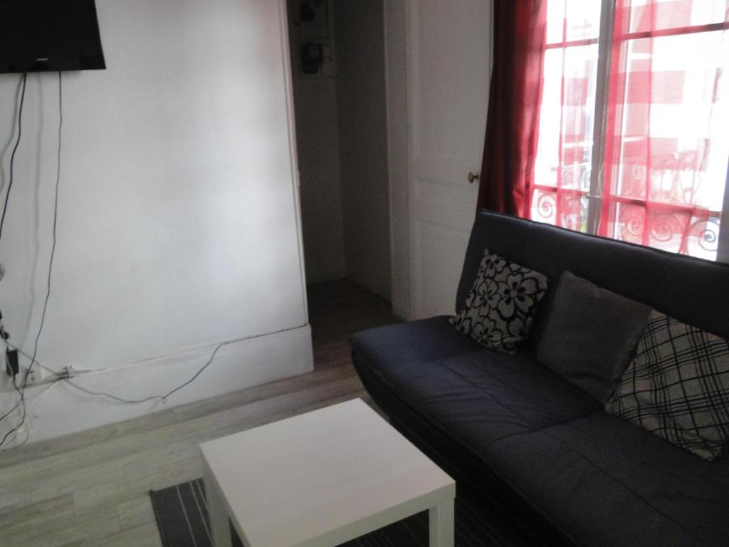 un salon avec un canapé et une table dans l'établissement Appartement Odéon a 5 minutes de la Seine, à Paris