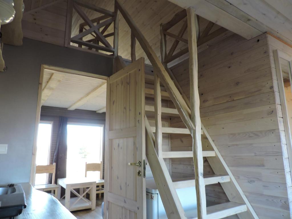 a loft bed in a room with an open door at Camping Zaki house No 9 in Jūrkalne