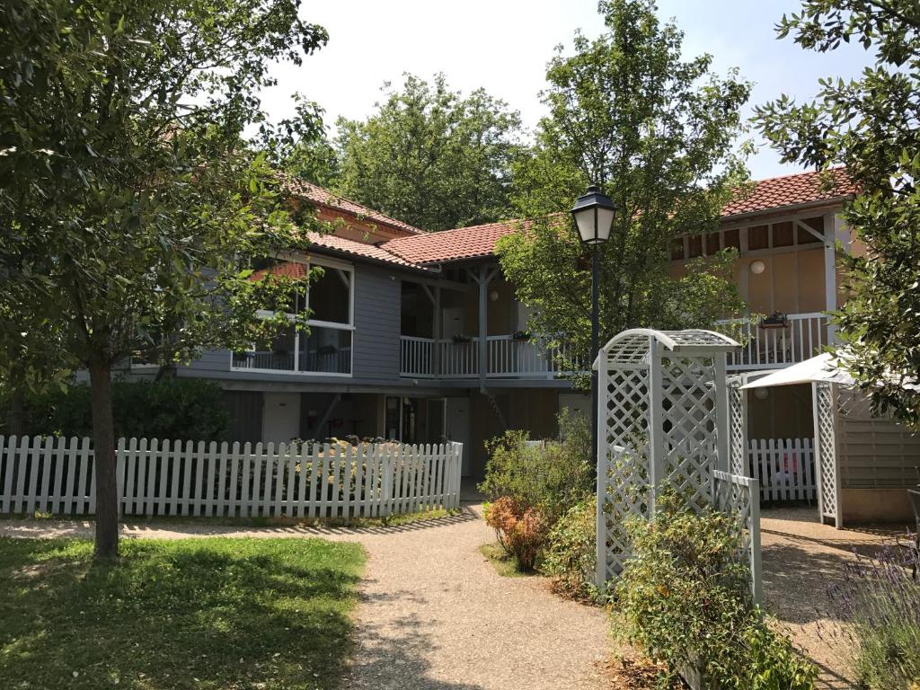 una casa con una valla blanca en Le bistrot d eugenie, en Eugénie-les-Bains