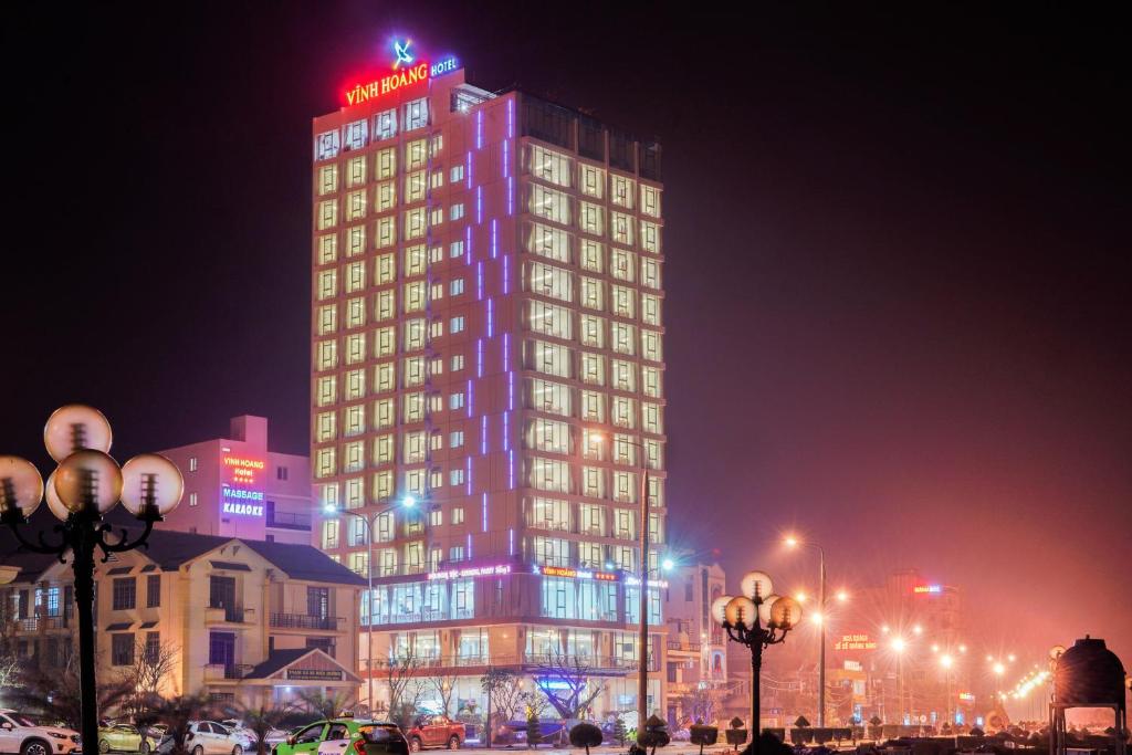 洞海的住宿－文晃酒店，一座高大的建筑,上面有 ⁇ 虹灯标志