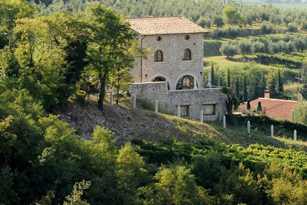 un grande edificio in pietra su una collina alberata di Villa San Giorgio a SantʼAmbrogio di Valpolicella