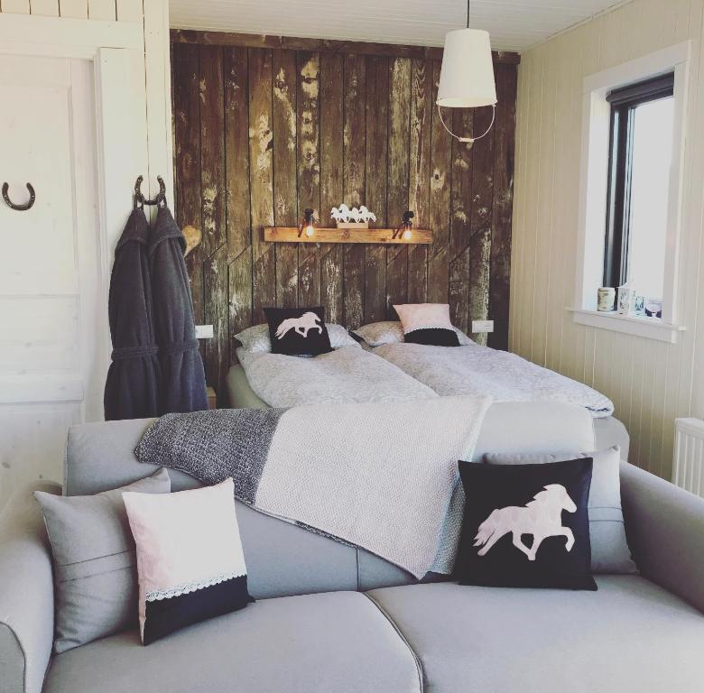 a bedroom with a bed and a couch with pillows at Akurgerði Guesthouse 8 - Country Life Style in Ölfus