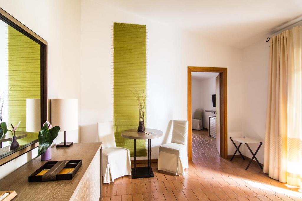 a living room with a table and white chairs at Hotel Aquadulci in Chia