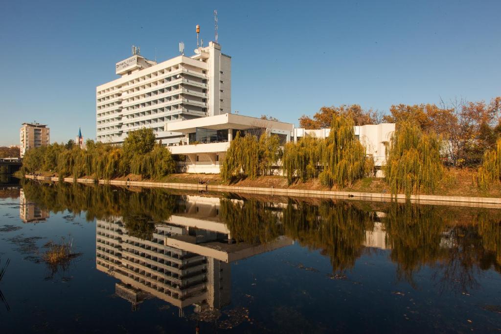 a building next to a river with a building at Continental Forum Oradea in Oradea