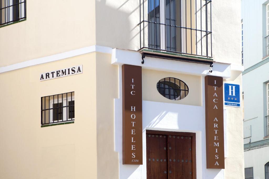 un edificio con una puerta y una señal en él en Itaca Artemisa by Soho Boutique en Sevilla