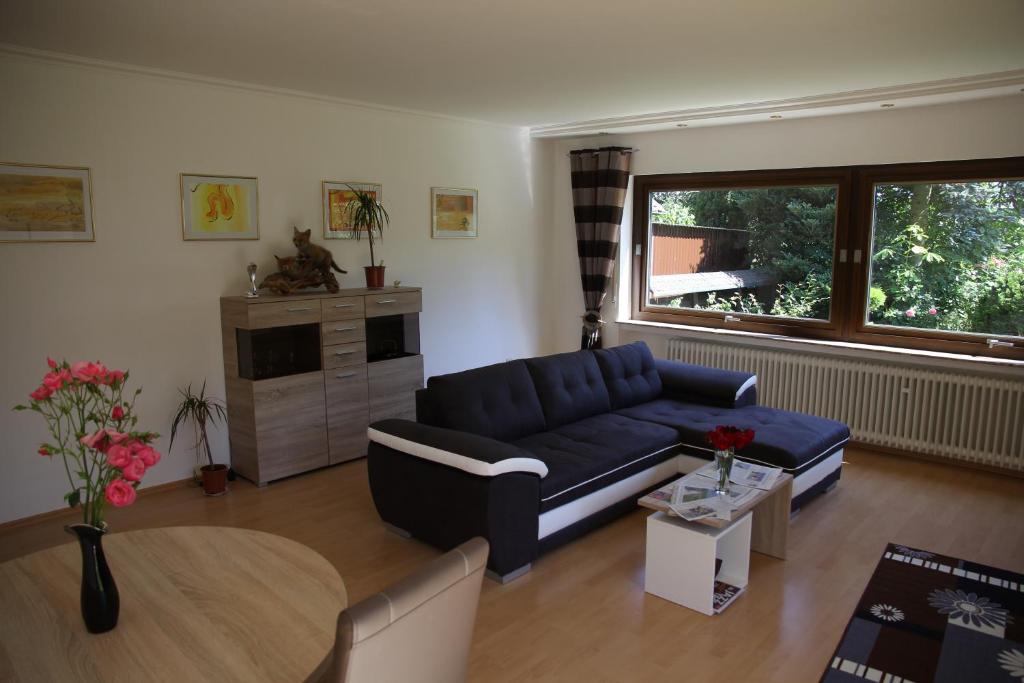 a living room with a blue couch and a table at Haus Panoramaweg in Sohren