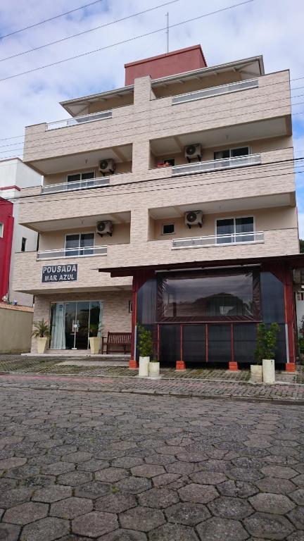 un grande edificio con un negozio di fronte di Pousada Mar Azul a Bombinhas