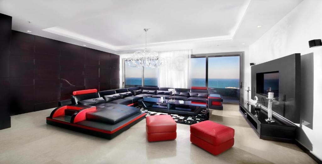a living room with a couch and a television at The Royal Penthouse in Bat Yam