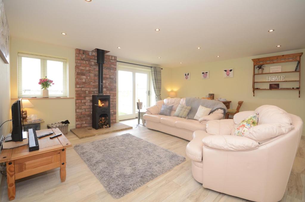 uma sala de estar com dois sofás brancos e uma lareira em The Piglets em York