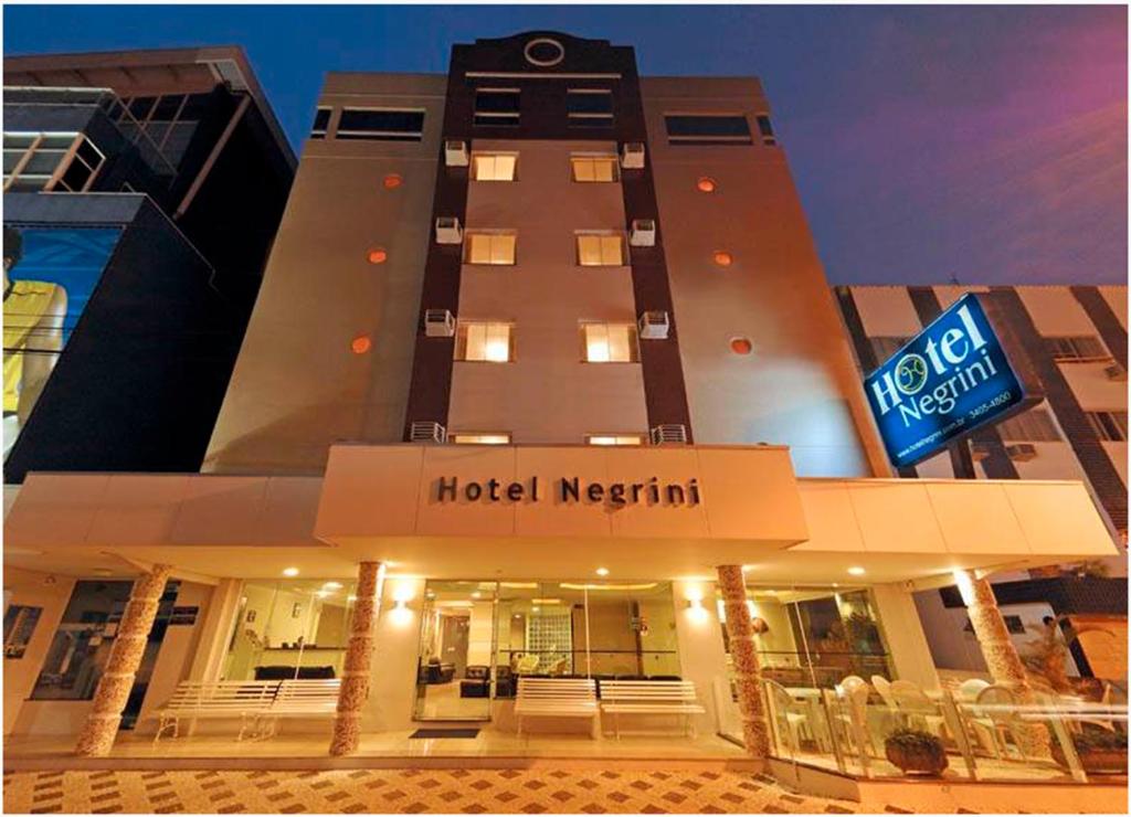 un edificio del hotel neptune con una señal de hotel merrill en Hotel Negrini, en Balneário Camboriú