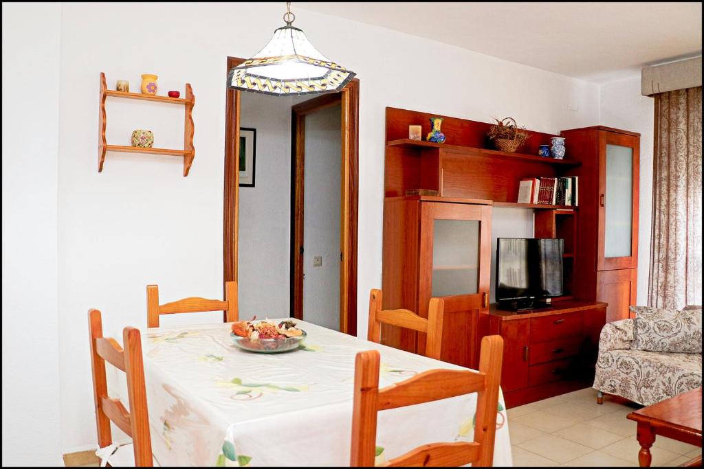 a dining room with a table and a television at Apartamento El Carmen in Barbate